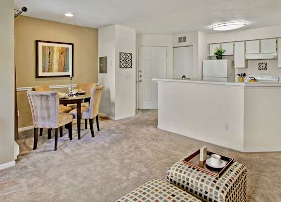 A kitchen and dining area with a table and chairs.