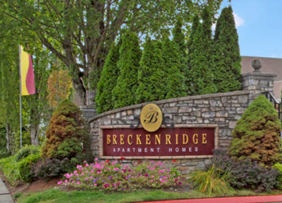 A sign for Breckenridge Apartment Homes is displayed in front of a landscaped area.