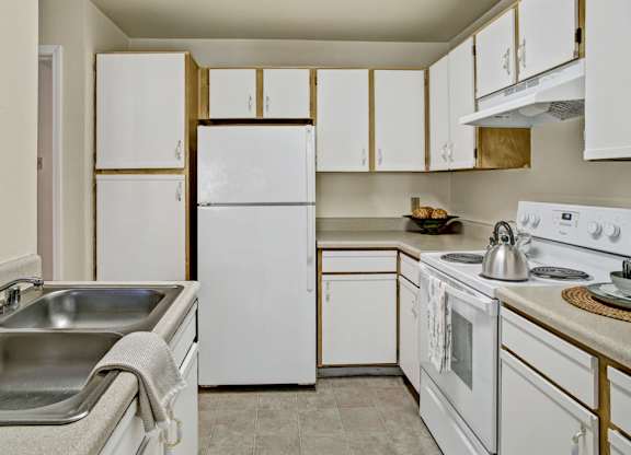 A kitchen with white appliances and cabinets.