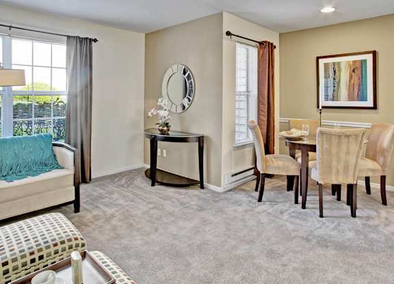 A bedroom with a bed, chair, and a painting on the wall.