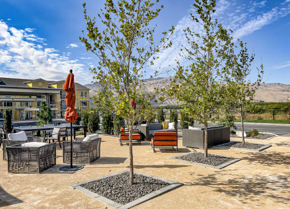 an outdoor patio with trees and a building in the background