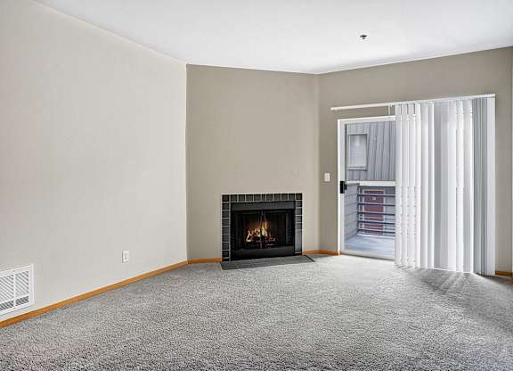 A living room with a fireplace and a carpeted floor.