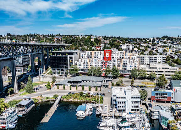 A cityscape with a bridge, buildings, and boats.