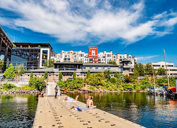 A person is sitting on a dock by the water.