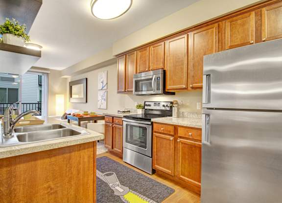 A kitchen with wooden cabinets and a stainless steel refrigerator.
