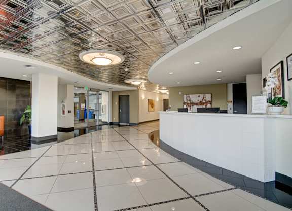 A reception area with a white reception desk and a tiled floor.