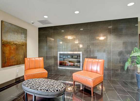 A living room with a grey and orange theme.