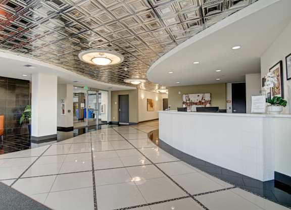 A reception area with a white reception desk and a tiled floor.