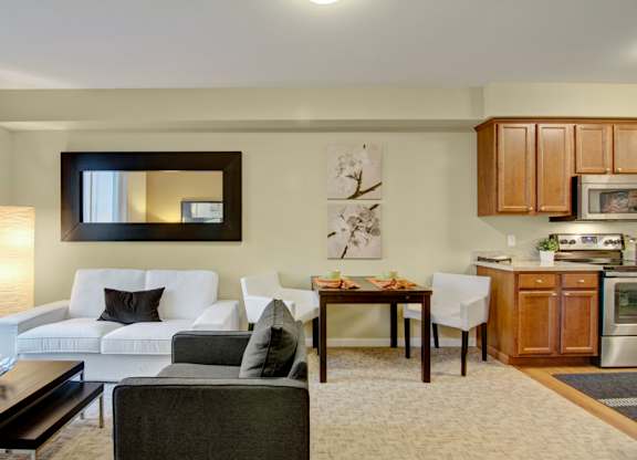A modern living room with a white couch and a dining table.