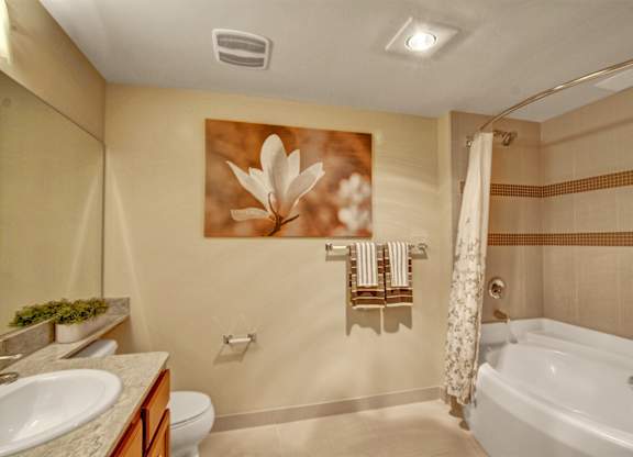 A bathroom with a white bathtub, a sink, and a toilet.