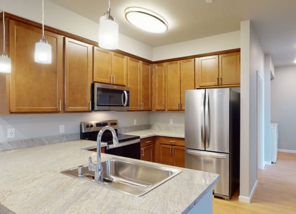 a kitchen with wooden cabinets and stainless steel appliances