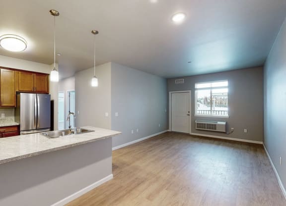 an empty kitchen and living room with a large window