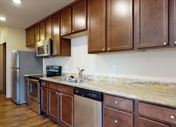 a kitchen with wooden cabinets and granite countertops