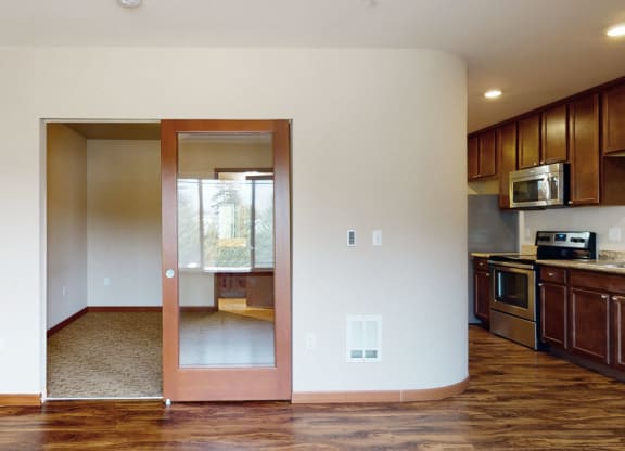 a kitchen and living room with wood floors and white walls