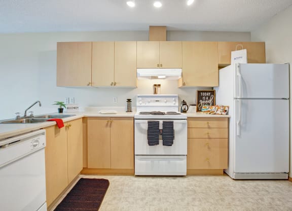 Bright kitchen here at Westhaven Estates Apartment Homes with light wood cabinets, white appliances, and decor reading "Today is a good day." A cozy and welcoming atmosphere.