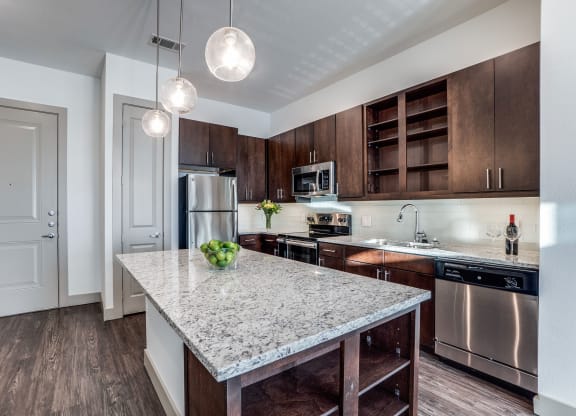 The Crosby at The Brickyard modern kitchen with granite countertops and wooden floors Apartments near DFW