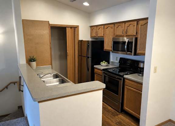 A kitchen with a sink, stove, and refrigerator.