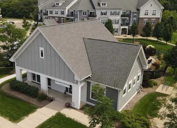 A house with a grey roof is surrounded by other houses.