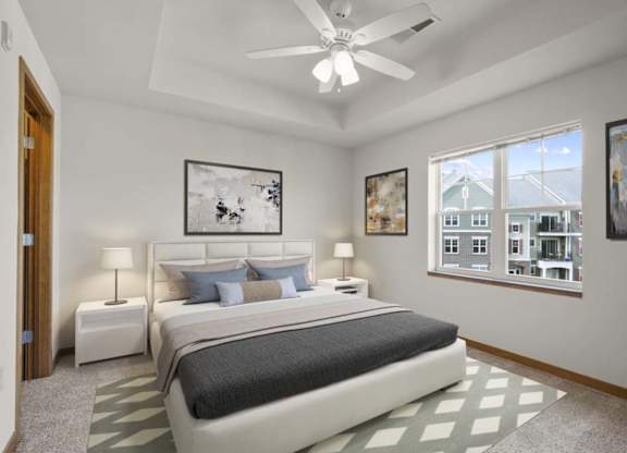 A bedroom with a large bed and a ceiling fan.