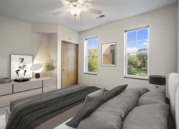 A living room with a grey couch and a ceiling fan.