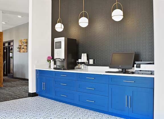 A blue and white kitchen with a microwave, oven, and a laptop on the counter.