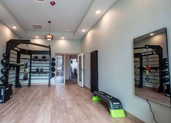 A modern fitness studio here at Van Buren East with free weights, training racks, and open workout space. Large mirrors and sleek flooring create a bright, motivating, and inviting environment.