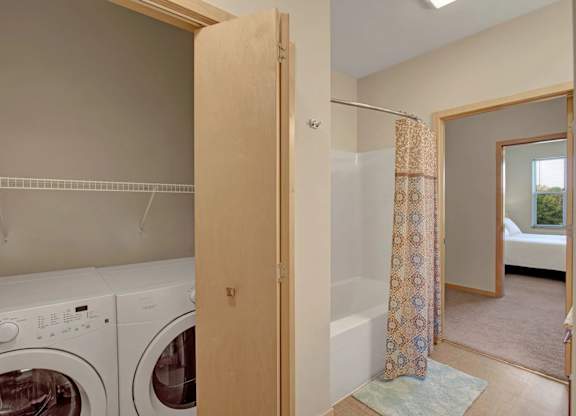 A laundry area here at Van Buren Place featuring in-unit washer and dryer, light wood trim, and a clean, convenient layout that feels bright and functional.