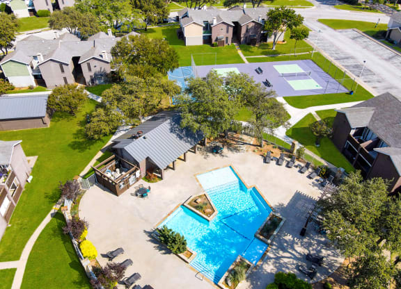 an aerial view of a yard with a swimming pool and houses