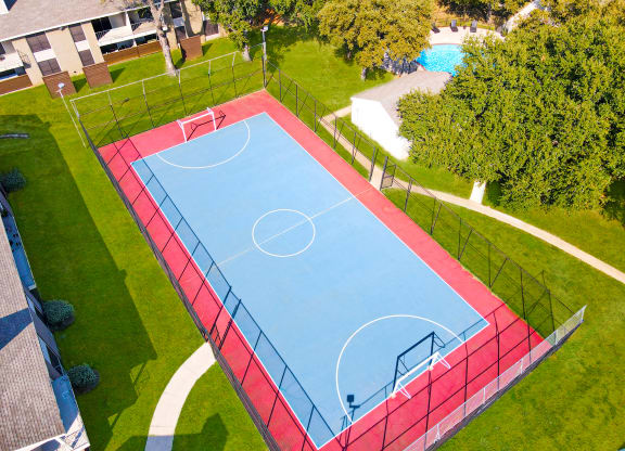 an aerial view of a blue and red sports court in a park