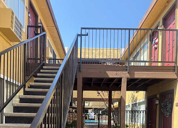 A staircase with a metal railing leads to a balcony.