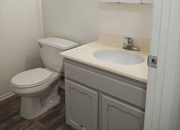 A white toilet sits next to a sink in a small bathroom.