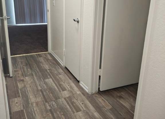 A hallway with white doors and a grey carpet.