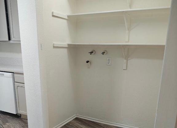 A room with a wood floor and white walls.