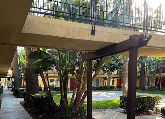 A walkway with a metal railing and a concrete floor.