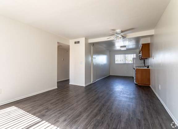 A room with a ceiling fan and a cabinet in it.