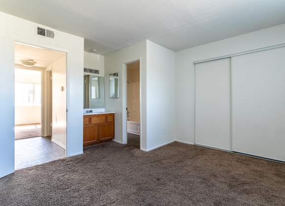 A room with a brown carpet and white walls.