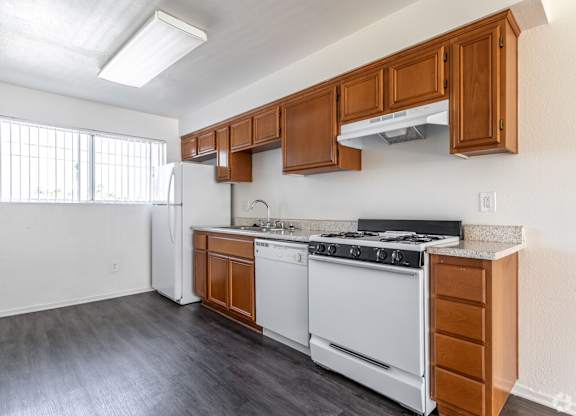 A kitchen with white appliances and wooden cabinets.