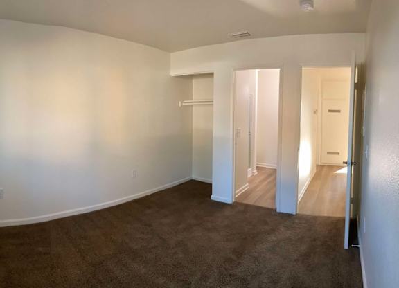 A large empty room with carpeted floor and white walls.