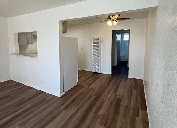 A room with wooden floors and a ceiling fan.