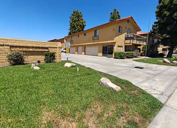 A yellow house with a garage and a driveway in front.