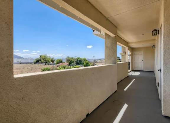 A balcony with a view of the mountains and a clear blue sky.