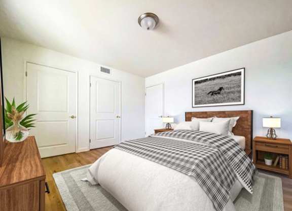 A bedroom with a bed, nightstands, and a plant.
