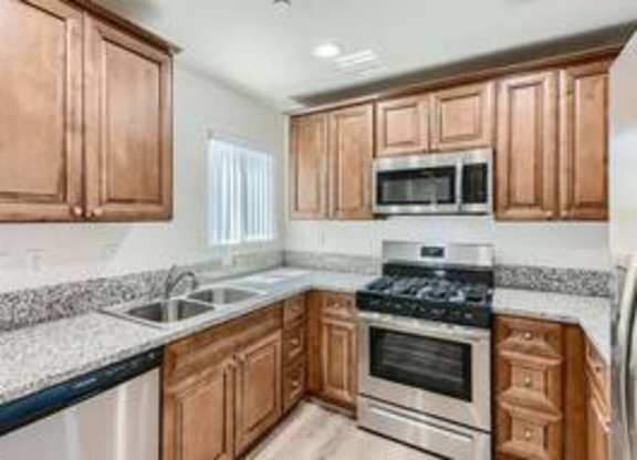 A kitchen with wooden cabinets and a granite countertop.