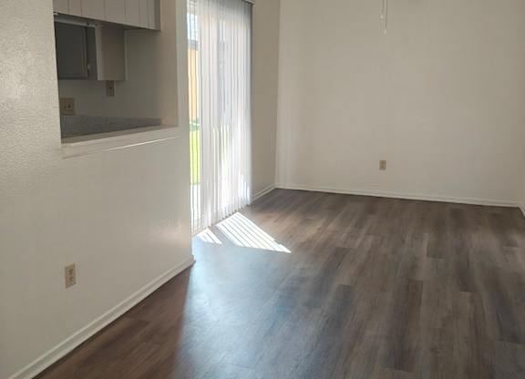A room with a ceiling fan and wooden flooring.