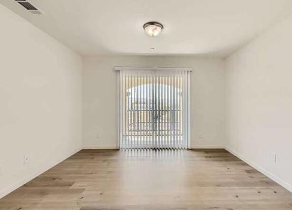A room with a sliding door and wooden floor.