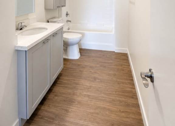 A white bathroom with a toilet, sink, and bathtub.