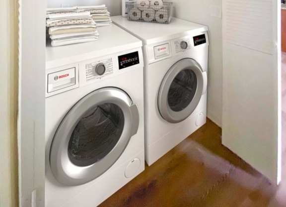 A small laundry room with a washer and dryer.