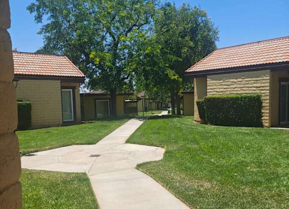 A pathway leads to a small building with a red roof.