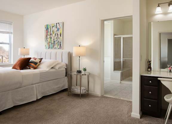 A bedroom with a bed, desk, and chair.