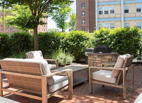 Peaceful outdoor firepit area with premium patio furniture at Bridgepoint apartments in Bayonne